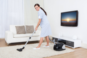 woman cleaning the carpet with vacuum cleaner